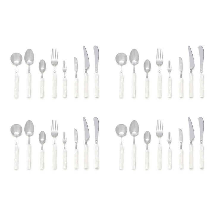 Four place settings of stainless steel flatware with white bamboo-shaped handles