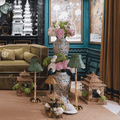 Elegant living room featuring a bamboo rechargeable lamp with seagrass shade, colorful vases, and decorative accents.